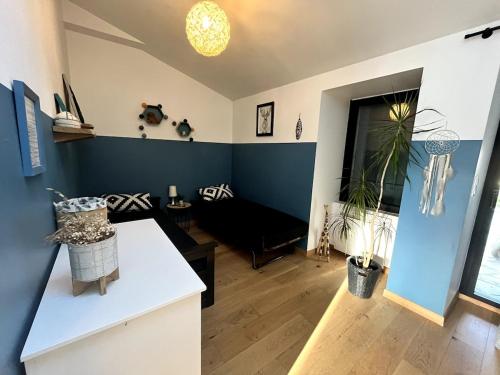 un salon avec un mur d'accent bleu dans l'établissement Divatte, Belle maison 8 pers en bord de Loire, à Divatte sur Loire