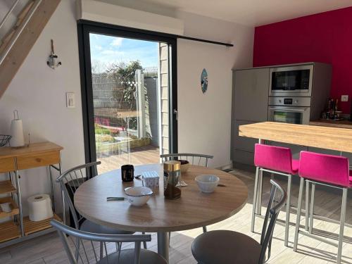 une salle à manger avec une table et des chaises et une cuisine dans l'établissement Charmante maison bretonne avec jardin clos, parking, WiFi, à 900m de la plage - Trégastel - FR-1-542-35, à Trégastel