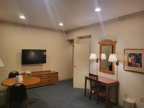 a room with a desk and a television and a table at Roosevelt Inn at Roosevelt Blvd, Philadelphia, PA in Philadelphia