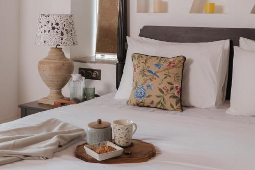a bed with a tray of food and a lamp at ELIVAAS Maison 10 - Luxe 4 BHK Villa With Pvt Pool, Garden & Portuguese Charm in Siolim