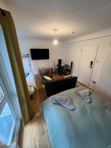 a bedroom with a bed and a living room with a tv at Royal Height - 3 bed in Wembley in London