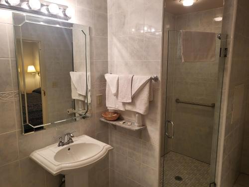 a bathroom with a sink and a shower with a mirror at Roosevelt Inn at Roosevelt Blvd, Philadelphia, PA in Philadelphia