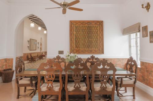 a dining room with a table and a ceiling fan at ELIVAAS Maison 10 - Luxe 4 BHK Villa With Pvt Pool, Garden & Portuguese Charm in Siolim