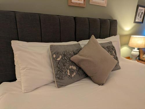 a bed with a bunch of pillows on it at Seven Stars in Ledbury