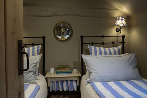 - une chambre avec 2 lits dotés d'oreillers rayés bleus et blancs dans l'établissement Worstead Cottage by Big Skies Cottages, à Worstead