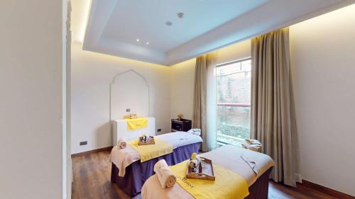 a room with two beds and a mirror at Radisson Collection Hotel & Spa, Riverfront Srinagar in Srinagar