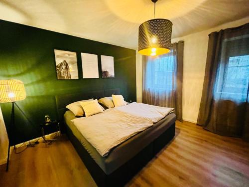 a bedroom with a bed with a green wall at Ferienwohnung Michaela in Neualbenreuth