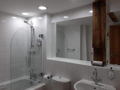a bathroom with a sink and a tub and a toilet at Seven Stars in Ledbury