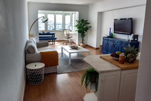 a living room with a couch and a table at Caparica Beachfront Oceanview in Costa da Caparica