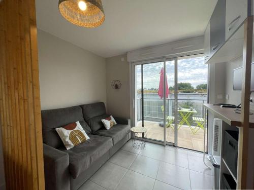 d'un salon avec un canapé et un balcon. dans l'établissement Studio LA ROCHELLE - LR340-D206, à La Rochelle