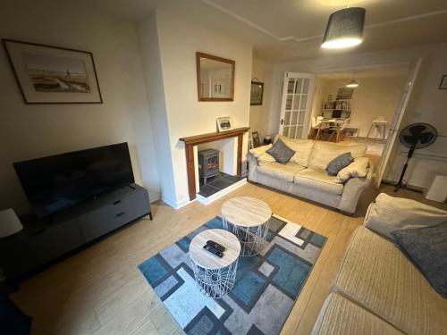 a living room with a couch and a fireplace at 1 bed annex with extra sofa bed ideal for families and business guests in Littleport