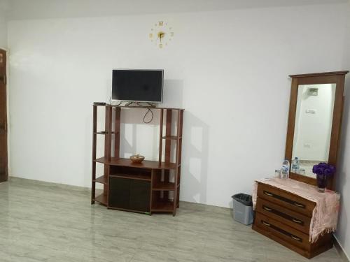 a room with a tv and a dresser and a mirror at Sunrise Relax Inn in Beruwala