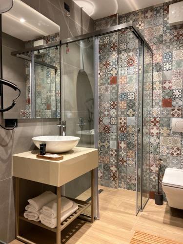 a bathroom with a sink and a shower at Coastline Luxury Apart Hotel in Golem