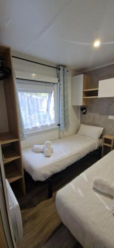 une petite chambre avec deux lits et une fenêtre dans l'établissement Evasion au bord de l'océan, à Capbreton