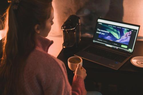 a woman sitting at a table with a laptop computer at Svalbard Hotell | Polfareren in Longyearbyen