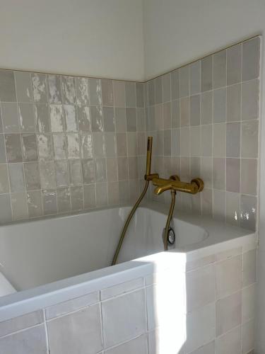 a bath tub with a faucet in a bathroom at La Rochelle Exceptional Property, Park, Pool, in La Rochelle