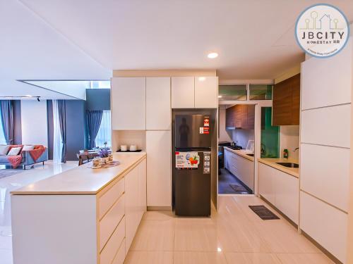 a kitchen with a refrigerator in the middle of it at Medini Signature Suites by RR JBcity in Nusajaya