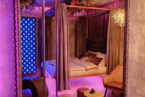 a bedroom with a canopy bed in a purple room at Story Rooms in Olomouc