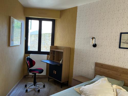 une chambre avec un lit, un bureau et une chaise dans l'établissement Chez Fabienne, tout à pied, à Saint-Malo
