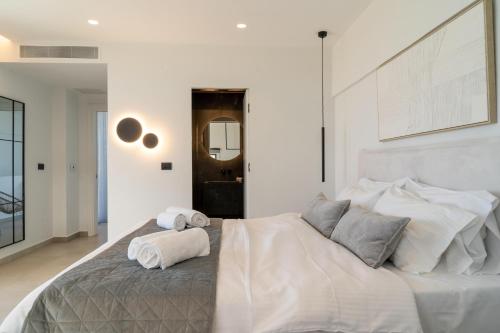 a white bedroom with a large bed with towels on it at Aethra Villas Luxury Retreat in Anissaras