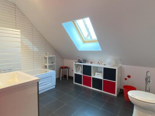 a bathroom with a sink toilet and a skylight at La Clairière in Jullouville-les-Pins