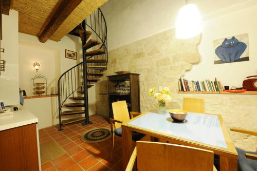 a living room with a table and a spiral staircase at Casa.Peiso in Mörbisch am See