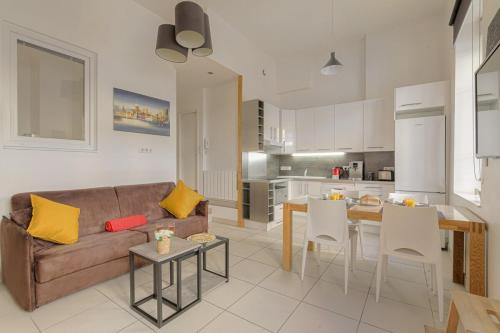 un salon avec un canapé et une table et une cuisine dans l'établissement Charmand et Cosy avec emplacement idéal, à Lyon