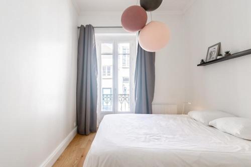 - une chambre avec un lit avec des ballons sur le mur dans l'établissement Le 37 - Hypercenter & Modern, à Dijon