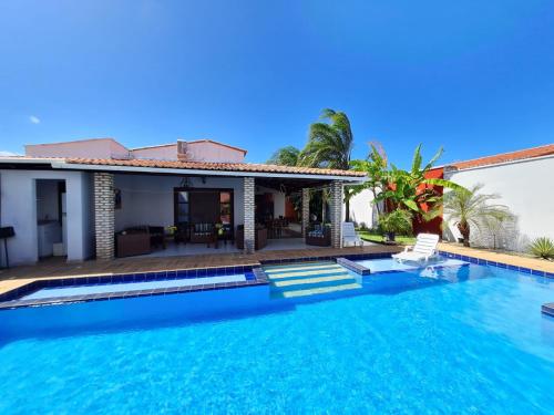 a villa with a swimming pool and a house at Casa Jardim Beija-flor in Touros