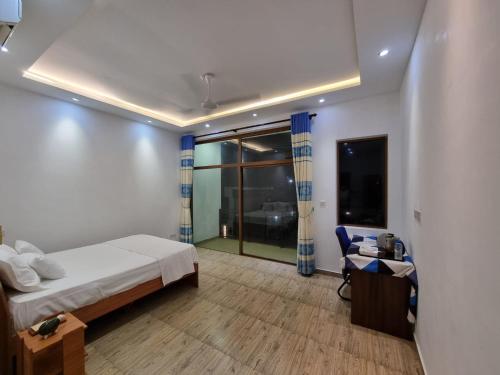 Walgama SouthにあるUtopia Polhena Hotelのベッドと机と窓のある寝室