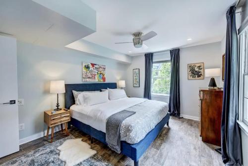 a bedroom with a blue bed and a window at Experience Myers Park in Style in Charlotte