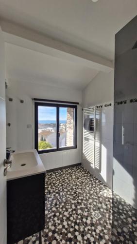 une salle de bain avec un lavabo et une grande fenêtre dans l'établissement Le bateau de Sète, à Sète