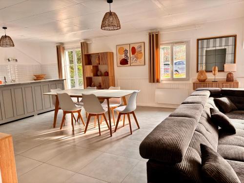 un salon avec un canapé, une table et des chaises dans l'établissement Les Chardonnays, à Baroville