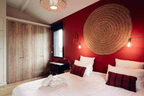 - une chambre avec des murs rouges et un grand lit blanc dans l'établissement Maison des Dunes, à Saint-Julien-en-Born