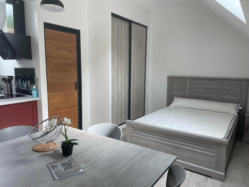 une chambre avec un lit, une table et des chaises dans l'établissement gîte Ludivine, à Francueil