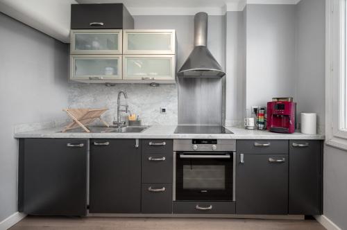 - une cuisine avec des armoires noires et une cuisinière dans l'établissement Cozy Appartement close to Port of Nice, à Nice
