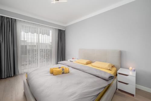 - une chambre blanche avec un grand lit et des oreillers jaunes dans l'établissement Cozy Appartement close to Port of Nice, à Nice