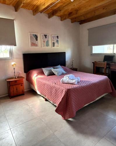 a bedroom with a bed with a red bedspread at LA CLARITA Chapadmalal in Chapadmalal