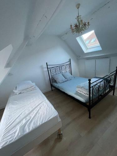 une chambre avec deux lits dans un grenier dans l'établissement Appartio - Grande maison proche PARIS, à Villiers-le-Bel