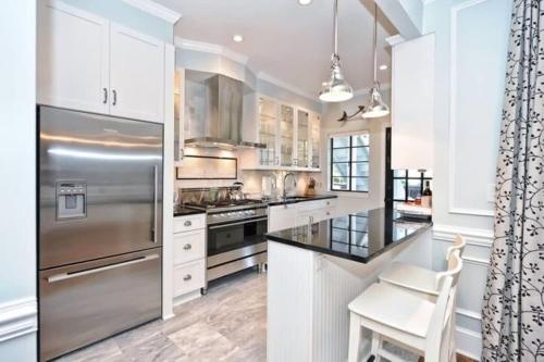 a kitchen with white cabinets and a stainless steel refrigerator at Relax or Entertain in Luxurious 2BR with Patio in Charlotte