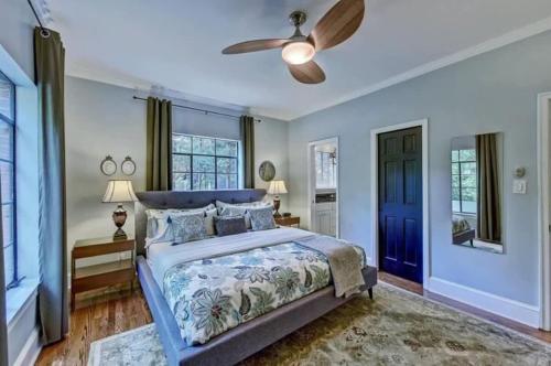 a bedroom with a blue bed and a ceiling fan at Elegant 2BR with Covered Patio in Charlotte