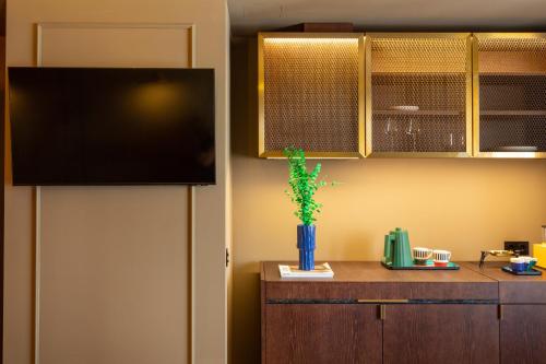 a room with a tv and a vase with a plant at Upon Angels - Adults Only in Lisbon