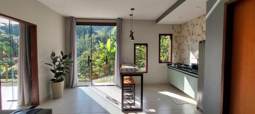 a kitchen with a counter and a large window at Casa da Bella - 1,5km do centro de Lumiar in Nova Friburgo