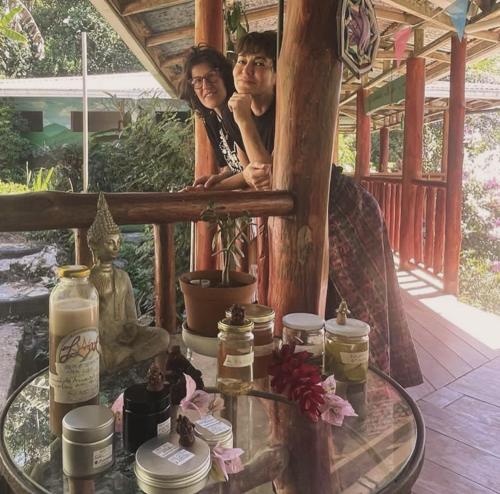 a man and woman sitting on a porch with a glass table at Montaña Verde in Rivas