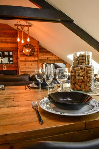 a wooden table with a plate of food and wine glasses at Villa du Parc le Châtaignier in Formiguères