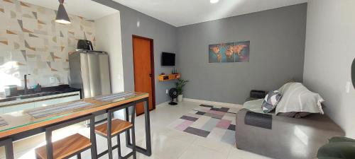 a kitchen with a counter and a table and a refrigerator at Casa da Bella - 1,5km do centro de Lumiar in Nova Friburgo