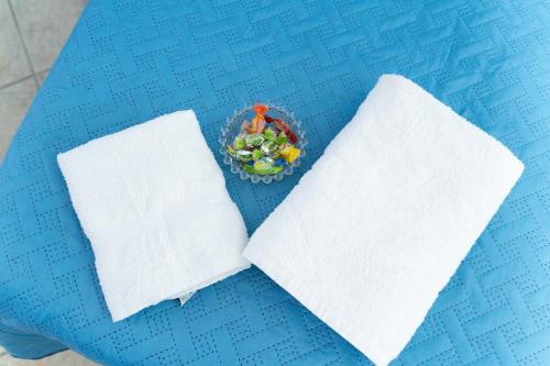 a blue table with two napkins and a bowl of fruit at The Brothers B&B in Ercolano