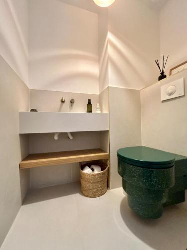 La salle de bains est pourvue de toilettes vertes et d'un lavabo. dans l'établissement Villa Stella-plage proche Le Touquet pour 8 personnes, à Cucq