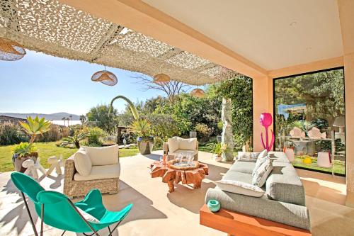 a patio with chairs and a couch and a table at Villa Bayugita in Port Grimaud