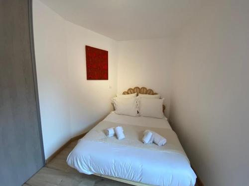 - un lit dans une chambre avec 2 serviettes dans l'établissement Chez Victor - parking, balcon, proche lac & rando, à Veyrier-du-Lac